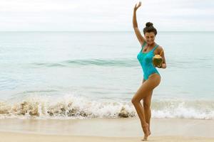 femme heureuse avec une noix de coco sur la plage photo