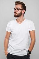 Homme barbu élégant à lunettes sur fond gris photo