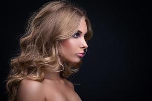 femme blonde aux cheveux ondulés et maquillage coloré photo