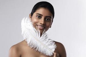 jeune et sensuelle femme indienne avec une douce plume d'autruche photo