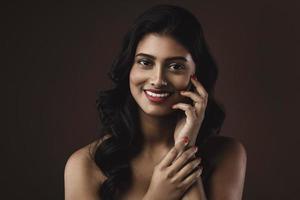 femme indienne avec beau maquillage et coiffure sur fond marron photo