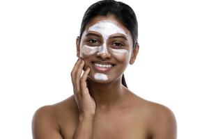 jeune femme indienne avec un masque nettoyant appliqué sur son visage photo