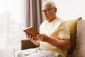 homme âgé lisant la sainte bible à la maison photo