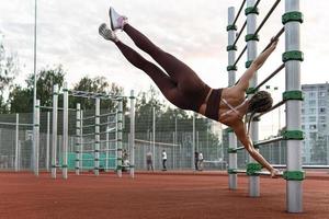 une femme forte fait un exercice de drapeau humain pendant son entraînement de gymnastique suédoise photo