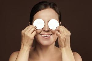 belle femme d'âge moyen avec des tampons de coton pour le nettoyage du visage ou la routine de démaquillage photo