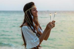 femme heureuse avec un cierge magique sur la plage photo