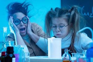 professeur et petite fille pendant la leçon de chimie mélangeant des produits chimiques dans un laboratoire photo