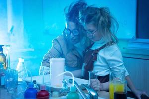 professeur et petite fille pendant la leçon de chimie mélangeant des produits chimiques dans un laboratoire photo