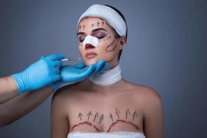 une femme enveloppée de bandages et de cicatrices est préparée pour une autre opération. photo