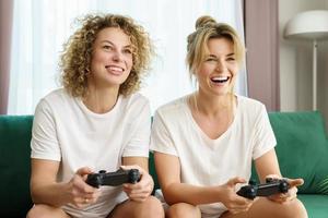 deux belles filles jouant à la console de jeux vidéo dans le salon photo