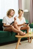 deux belles filles jouant à la console de jeux vidéo dans le salon photo