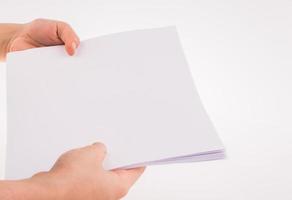 main tenant une feuille de papier vierge blanche photo