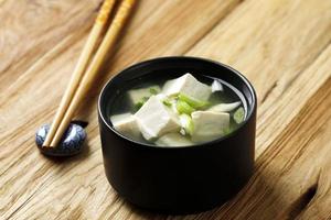 soupe japonaise au tofu miso sur bol en céramique noire photo