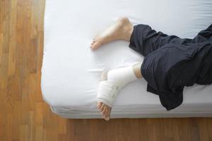 femme avec pied bandé sur la vue de dessus de lit photo