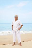 heureux homme âgé marchant sur la plage photo