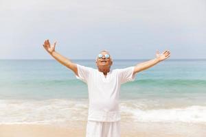 heureux homme âgé marchant sur la plage photo