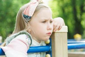 portrait de petite fille triste dans un parc de la ville photo