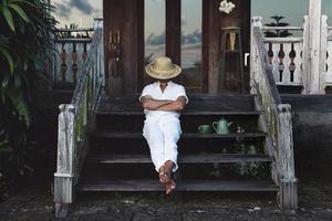 jeune agriculteur assis sur le porche de sa maison photo