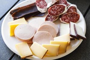 assiette pleine de collations savoureuses comme du fromage et de la viande. photo