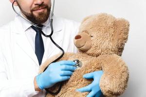 pédiatre professionnel avec un ours en peluche dans ses mains photo