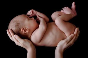 mignon bébé nouveau-né couché dans les mains de la mère photo