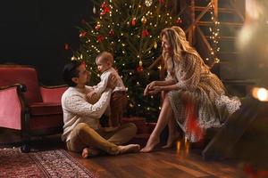 une jeune famille heureuse célèbre noël ou le nouvel an. photo