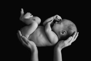mignon bébé nouveau-né dans les mains de la mère photo
