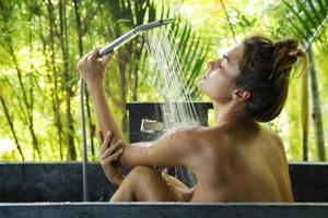 femme se lavant sous la douche dans une salle de bain en plein air photo