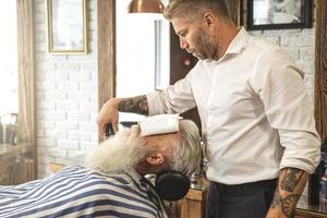 bel homme âgé se coiffant et taillant sa barbe photo