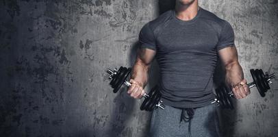 bodybuilder faisant des boucles de biceps avec des haltères photo