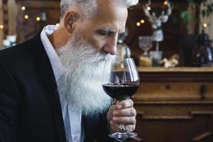 bel homme âgé barbu buvant du vin rouge photo