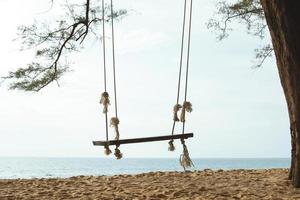 balançoire en bois avec vue sur la mer photo