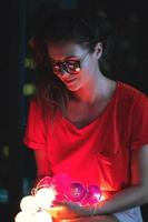 jeune femme avec reflet de boules de lumière rougeoyante dans ses lunettes photo