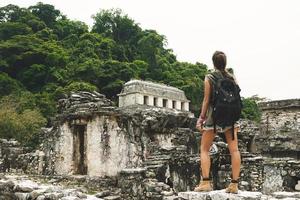 femme avec un sac à dos à côté d'anciennes ruines mayas photo