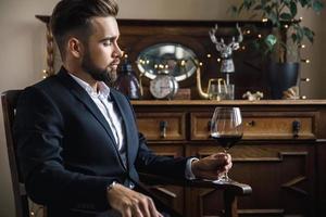 bel homme barbu avec un verre de vin rouge photo