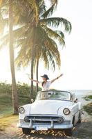 heureuse jeune femme et voiture décapotable rétro photo