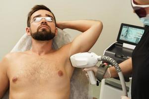 homme pendant la procédure de photoépilation dans une clinique médicale esthétique photo