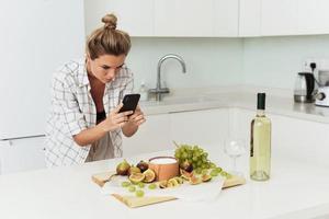 jeune jolie femme prenant une photo de son délicieux yaourt grec aux figues par son smartphone