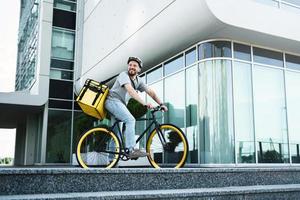 courrier de livraison express debout sur vélo avec sac isotherme. photo