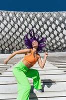 femme active portant des vêtements de sport colorés se produisant dans la rue pendant la journée d'été photo