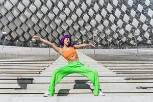 femme active portant des vêtements de sport colorés se produisant dans la rue pendant la journée d'été photo