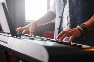 jeune homme joue du piano à la maison photo