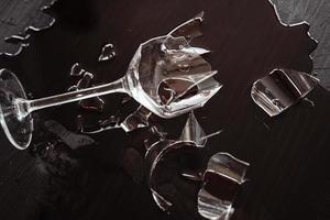 verre à vin cassé avec beaucoup d'éclats tranchants sur la table photo