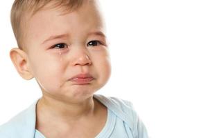 gros plan du visage d'un petit garçon qui pleure en barboteuse. photo