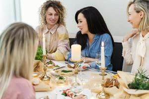 amis de jeunes femmes parlant à la table de fête. photo