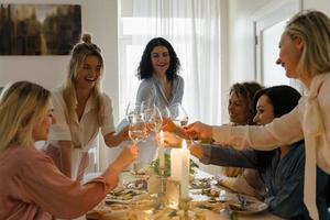 amis de jeunes femmes trinquant à la table de fête. photo