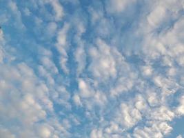 nuages blancs dans le ciel bleu. ciel et infini. beau fond bleu clair. peu nuageux, beau temps. nuages bouclés par une journée ensoleillée. photo