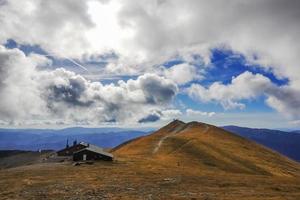 maison au sommet de la plus haute montagne de basse-autriche avec des nuages blancs photo