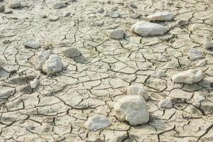 pierres blanches sur le sol d'un étang asséché avec des fissures photo