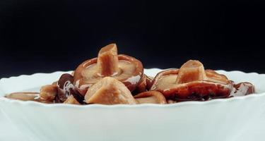 une assiette blanche de champignons marinés . nourriture de village saine. champignon de lait noir mariné . photo